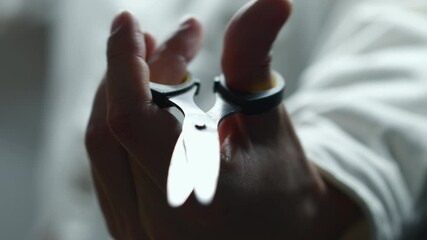 A man's hand on a white background uses sharp scissors.
A man clicks scissors demonstrating the principle of operation.
Sharp scissors with a steel blade