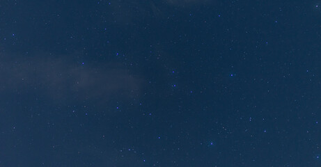 Panorama blue night sky milky way and star on dark background.Universe filled with stars, nebula and galaxy with noise and grain.Photo by long exposure and select white balance.Dark night sky.
