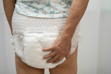 Asian senior woman patient wearing adult incontinence diaper pad in hospital.
