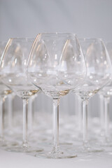A row of elegant empty wine glasses sparkles in soft focus, creating a refined and festive atmosphere
