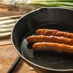 hot dogs are cooking in a hot cast iron pan