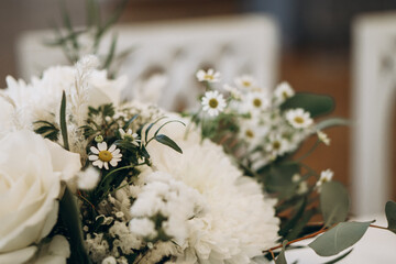 Elegant wedding banquet table decorated with white florals, glassware, and folded napkins for a...