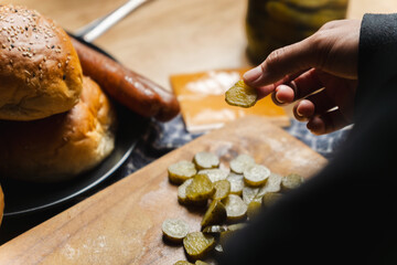 A person is cutting up pickles on a wooden cutting board