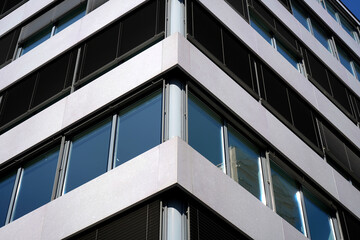 Modern office building with mirrored windows and horizontal lines. Concrete and glass dominate the...