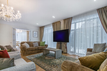 Magnificent interior design of the living room with luxurious sofas, a large TV and an elegant...