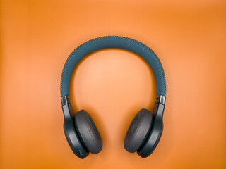Dark green big headphones on a plain bright orange background for banners, for advertising. copy space. High quality photo