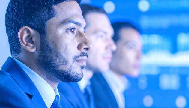 Realistic photo of a team in a video meeting with remote members on-screen. Modern hybrid work and digital collaboration concept.