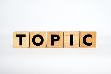 The word "TOPIC" spelled out using wooden blocks with bold black letters on a clean white background.