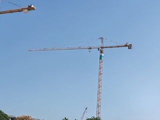 Tower crane or mobile crane erected beside under construction building.
Yellow color Building crane...