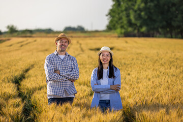 Two Farmers Smiling with Arms Crossed in Golden Wheat Field