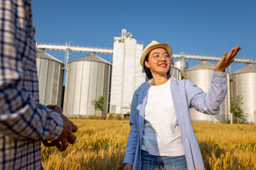  Two Silo Workers Standing in Wheat Field Discussing Future Tasks
