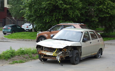 An old, broken-down light-colored car is parked in the yard, Dal'nevostochny Prospekt, Saint Petersburg, Russia, June 26, 2025 