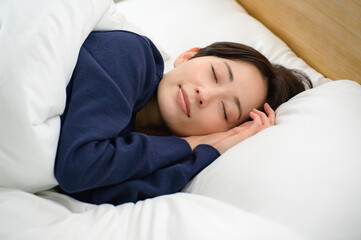 安心した表情で眠る女性のクローズアップが伝えるやさしい寝室の時間