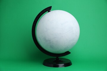 One white plastic model globe on green background
