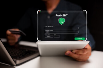A person holding a tablet and credit card, completing a secure online payment with a digital...