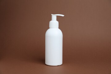 One white bottle of cosmetic product on brown background