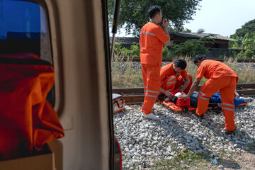 First responder rescue team helping unconscious accident man near train track 