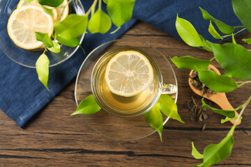 Refreshing green tea with lemon and leaves on wooden table, flat lay
