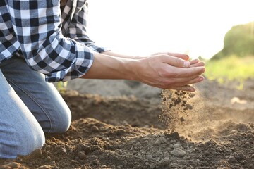 Man with pile of soil in field, closeup