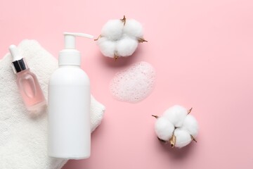 Flat lay composition with bottle of liquid soap and cotton flowers on pink background