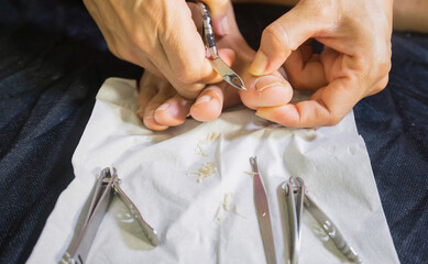 Portrait of a woman trimming her own nails