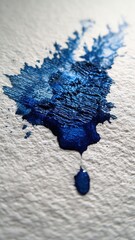 Vibrant blue paint splash on textured paper.
