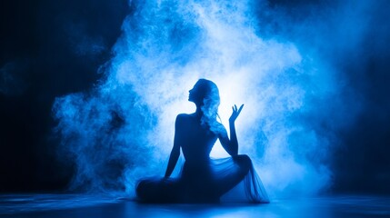 Obraz premium Silhouette of person meditating in foggy blue studio atmosphere calm spiritual yoga mindfulness peaceful focus