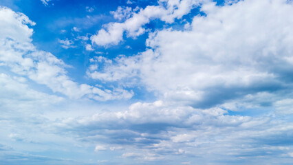 Vast blue sky filled with fluffy white clouds during daytime, creating a serene atmosphere. Ideal for backgrounds, nature themes, and weather-related concepts.