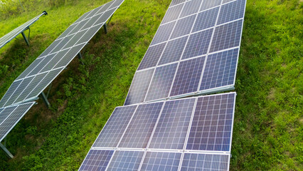 Aerial view of solar panels installed on a grassy slope. This renewable energy source demonstrates sustainability and innovation in technology.