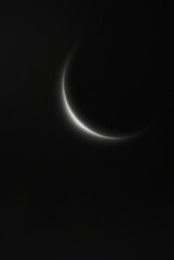 lunar crescent in night sky, sliver moon glow, dark sky crescent  
