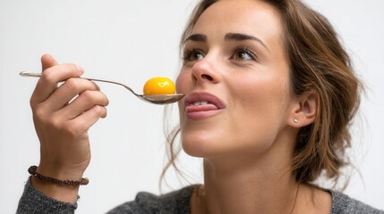 Woman Enjoying Gourmet Bite of Yellow Food on Spoon with Curiosity
