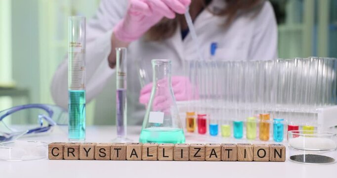 A skilled woman wearing a lab coat meticulously conducts various crystallization experiments using colorful solutions