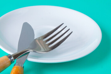 Close up Fork and knife on a empty plate.