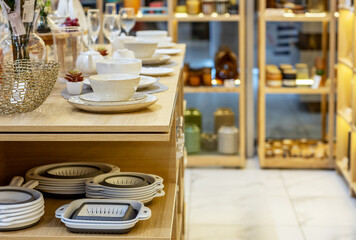 Shelves with porcelain tableware in the gift department of a shopping center
