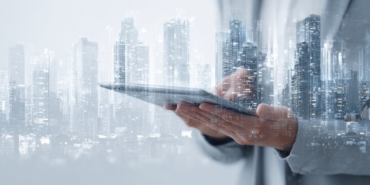 Person holding a tablet with a cityscape overlay