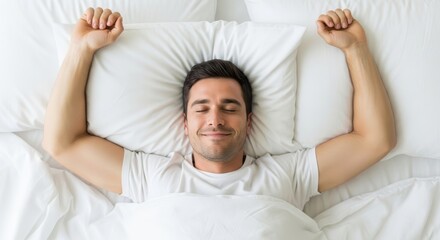 High-angle view of a relaxed man enjoying a refreshing morning stretch in crisp white bedding, embodying comfort and well-being.