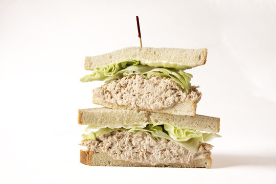 A tuna salad sandwich cut in half and stacked