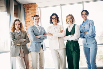 Portrait of a diverse and confident team of young professionals standing together in a modern office environment