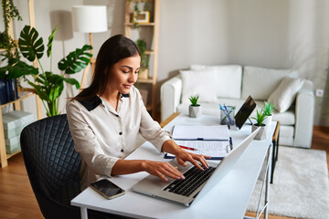 Young businesswoman working from home typing on laptop computer