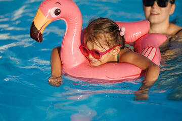 mom and daughter in pool have fun during summer vacation. Child having fun in swimming pool. 