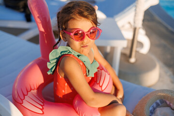 Funny little girl relaxing on summer vacation. The child has fun on the beach. Cute baby in a...