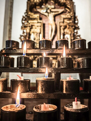 Votive candles flicker in prayer before Cristo de la Buena Muerte