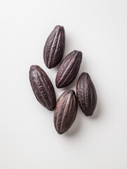 Obraz premium Five dark brown raw cocoa bean pods arranged on a white background cocoa beans cacao seeds