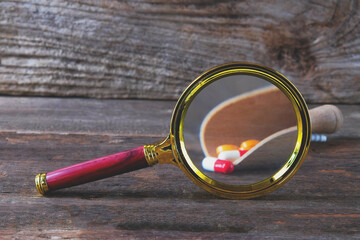 Magnifying glass with pharmaceutical medicine pills,