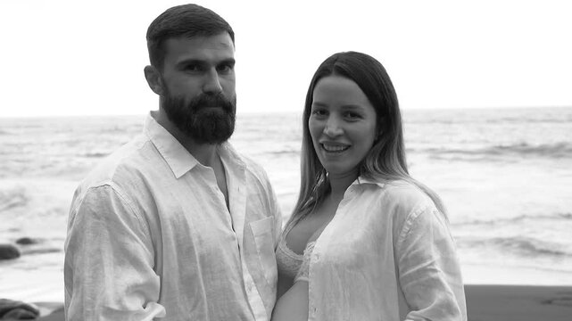 Young albanian couple having tender moment together during summer vacation on the beach - Pregnancy, parenthood and love concept - Black and white editing 