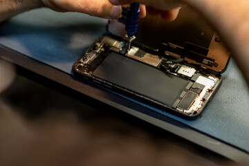 Expert Phone Repair Technician Replacing Components Inside a Smartphone at a Busy Repair Shop in the Early Afternoon