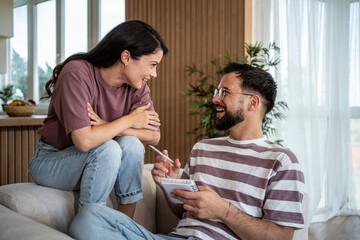 Fototapeta premium Couple planning future, taking notes and smiling at home