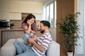 Happy couple relaxing on sofa, enjoying pregnancy test results