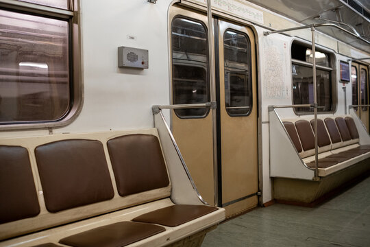 Empty Subway Train Interior Highlighting Brown Seating and Metal Railings During Off-Peak Hours