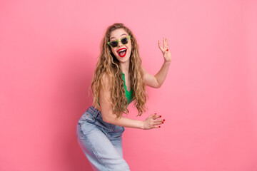 Excited young woman in stylish outfit enjoying vibrant pink background, expressing happiness and...